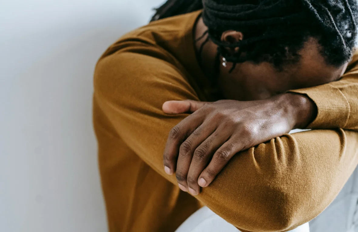Close-up of a man resting his head on his arms in a calm, reflective posture, symbolizing Mindfulness and Grounding Therapy in Tempe AZ.