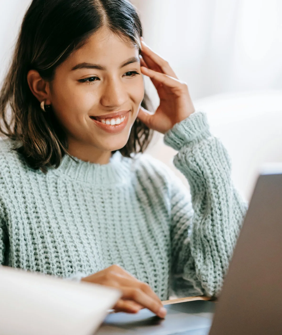 Smiling woman typing on laptop while reaching out to Onward Counseling through the online contact form in Tempe, AZ.